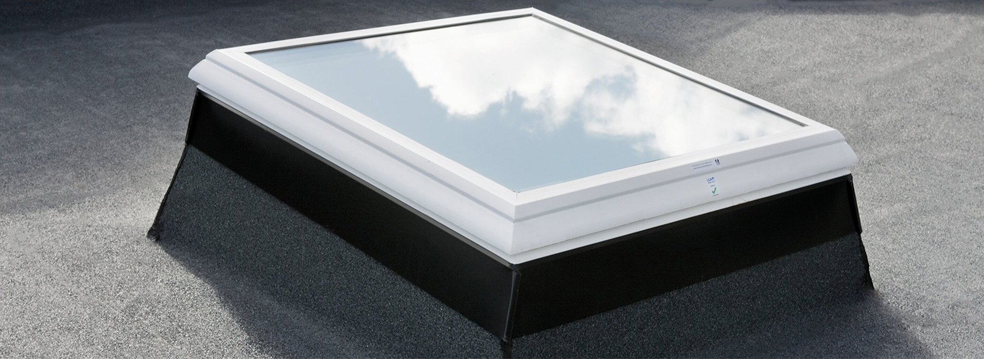 white framed glass skylight in flat roof